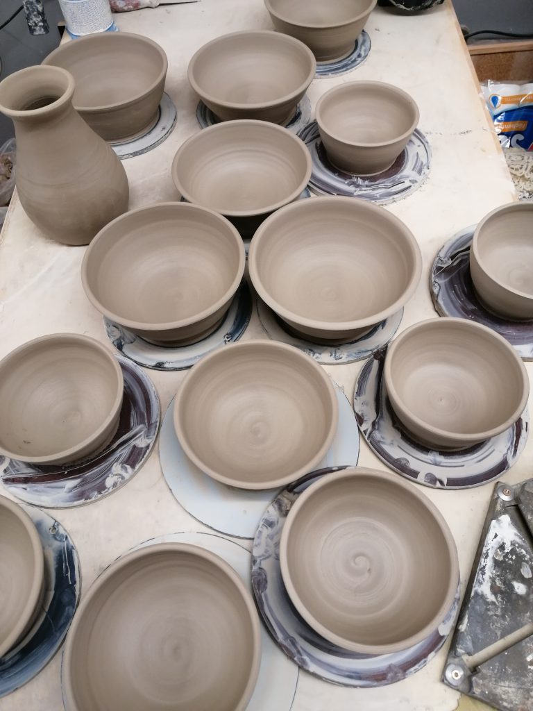 Auf der Scheibe gedrehte Müslischüsseln in der Töpferwerkstatt beim Trocknen